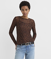 A woman in a leopard print top and jeans stands against a plain white background. carousel Product Image 1