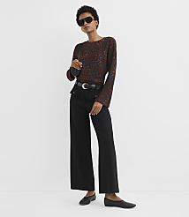 A woman in a leopard print top and black pants stands against a plain white background. carousel Product Image 2