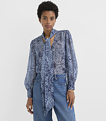 A woman in a blue paisley blouse and jeans stands against a plain white background. carousel Product Image 3