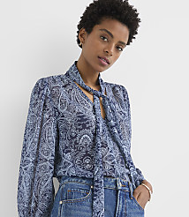 A woman in a blue paisley blouse and jeans stands against a plain white background. carousel Product Image 2