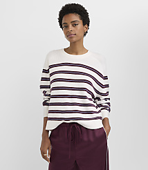 A woman in a striped sweater and burgundy pants stands against a plain gray background. carousel Product Image 1