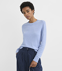 A woman in a light blue sweater and pinstripe pants stands against a plain white background. carousel Product Image 1