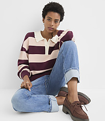 A woman in a striped sweater and cuffed jeans sits against a plain white background. carousel Product Image 1