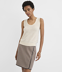 A woman in a cream-colored knit top and a brown patterned skirt stands against a plain white background. carousel Product Image 1