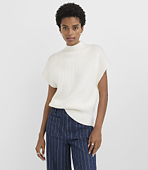 A woman in a white mock-neck sweater and striped pants stands against a plain white background. carousel Product Image 1