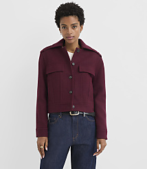 A woman in a maroon jacket and dark jeans stands against a plain white background. carousel Product Image 1