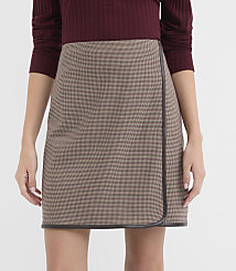 A woman in a brown and white patterned wrap skirt and a maroon top stands against a plain white background. carousel Product Image 2