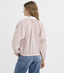 A woman in a pink and white striped blouse and blue jeans stands against a plain white background. carousel Product Image 3
