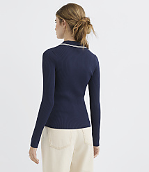 A woman in a navy ribbed sweater and cream pants stands against a plain white background. carousel Product Image 3