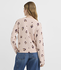 A woman in a light pink floral sweater and blue jeans stands against a plain white background. carousel Product Image 3