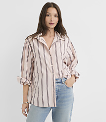 A woman in a pink and black striped button-down shirt and light blue jeans stands against a plain white background. carousel Product Image 1