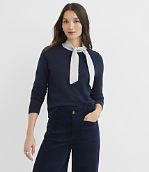 A woman in a navy sweater and corduroy pants stands against a plain white background. carousel Product Image 2