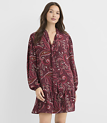 A woman in a burgundy paisley print dress stands against a plain white background. carousel Product Image 1