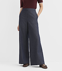 A person stands in dark wash wide-leg denim pants and a maroon top against a plain white background. carousel Product Image 2