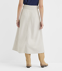 A woman in a beige skirt and tan boots stands against a plain white background. carousel Product Image 3