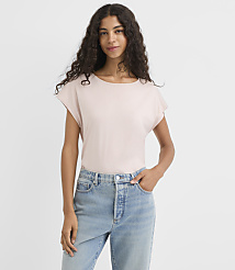 A woman in a light pink t-shirt and blue jeans stands against a plain white background. carousel Product Image 1