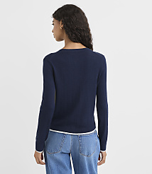 A woman in a navy sweater and jeans stands against a plain white background. carousel Product Image 3
