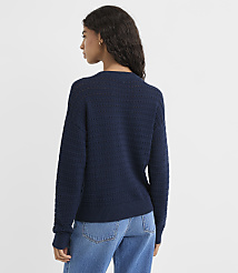 A woman in a navy blue textured sweater and jeans stands against a plain white background. carousel Product Image 3