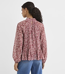 A woman in a floral print blouse and jeans stands against a plain white background. carousel Product Image 3