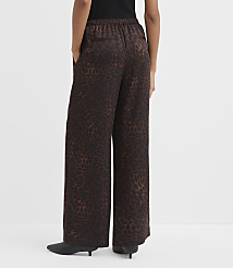 A person wearing wide-leg leopard print pants stands against a plain white background. carousel Product Image 3