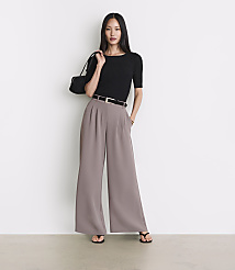 A woman in a black top and wide-leg pants stands against a plain white background. carousel Product Image 1