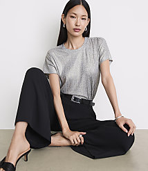 A woman in a silver t-shirt and black pants sits on a light-colored floor against a plain white background. carousel Product Image 2