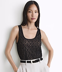 A woman in a black lace top and light-colored pants stands against a white background. carousel Product Image 2