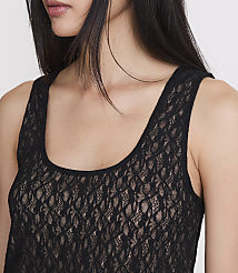 A woman's upper body is shown in the foreground, wearing a black lace tank top, with a plain white background. carousel Product Image 4