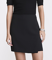 A woman in a black skirt and ribbed top stands against a plain white background, accessorized with rings and a bracelet. carousel Product Image 2