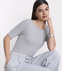 A woman in a grey ribbed top and light blue pants poses against a plain white background. carousel Product Image 2