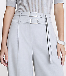 A person in a grey ribbed top and light grey pleated pants with a double buckle belt stands against a plain white background. carousel Product Image 4