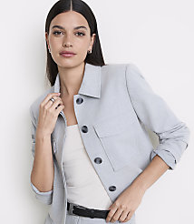 A woman in a light blue jacket and white top stands against a plain white background. carousel Product Image 2
