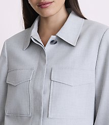 A woman in a light blue collared shirt with two chest pockets is shown from the chest up against a plain background. carousel Product Image 4