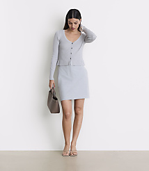 A woman in a light gray cardigan and skirt stands with a brown purse against a plain white background. carousel Product Image 1