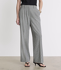 A person stands in front of a plain white background, wearing wide-leg, black and white patterned pants and black sandals. carousel Product Image 2