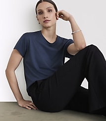 A woman in a navy t-shirt and black pants poses against a plain white background. carousel Product Image 2