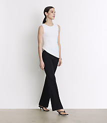 A woman in a white sleeveless top and black pants stands against a plain white background. carousel Product Image 1