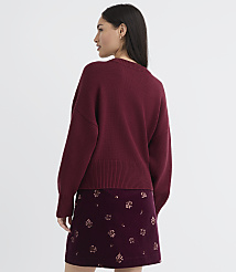 A woman in a maroon sweater and patterned skirt stands against a plain background. carousel Product Image 3
