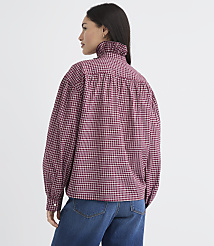 A woman in a red and black checkered blouse with a ruffled collar stands against a plain white background. carousel Product Image 4