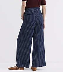 A person wearing navy pinstripe wide-leg pants and brown flats stands against a plain white background. carousel Product Image 3