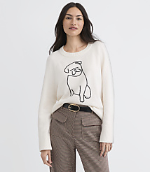 A woman in a cream sweater with a pug design stands against a plain white background. carousel Product Image 2