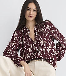 A woman in a floral blouse poses against a plain white background. carousel Product Image 1