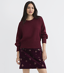 A woman in a maroon sweater and floral skirt stands against a plain white background. carousel Product Image 2