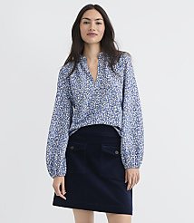 A woman in a floral blouse and dark skirt stands against a plain white background. carousel Product Image 1
