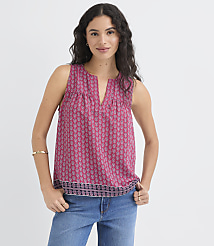 A woman in a patterned pink top and blue jeans stands against a plain white background. carousel Product Image 2