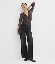 A woman in a sheer animal-print top and wide-leg jeans poses against a plain white background. carousel Product Image 2