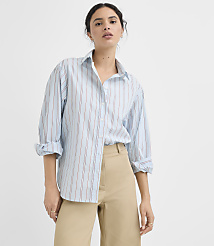 A woman in a light blue and red striped button-down shirt and tan pants stands against a plain white background. carousel Product Image 2