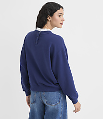 A woman in a blue sweatshirt and jeans stands against a plain white background. carousel Product Image 4