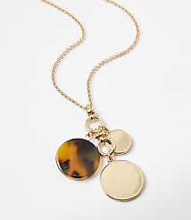 A gold chain necklace with a tortoiseshell pendant and two gold discs hangs against a plain white background. carousel Product Image 2