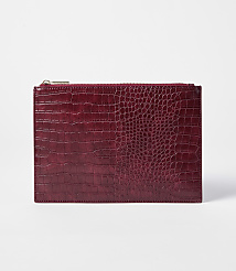 A deep red, crocodile-embossed clutch with a gold zipper rests on a plain white background. carousel Product Image 1